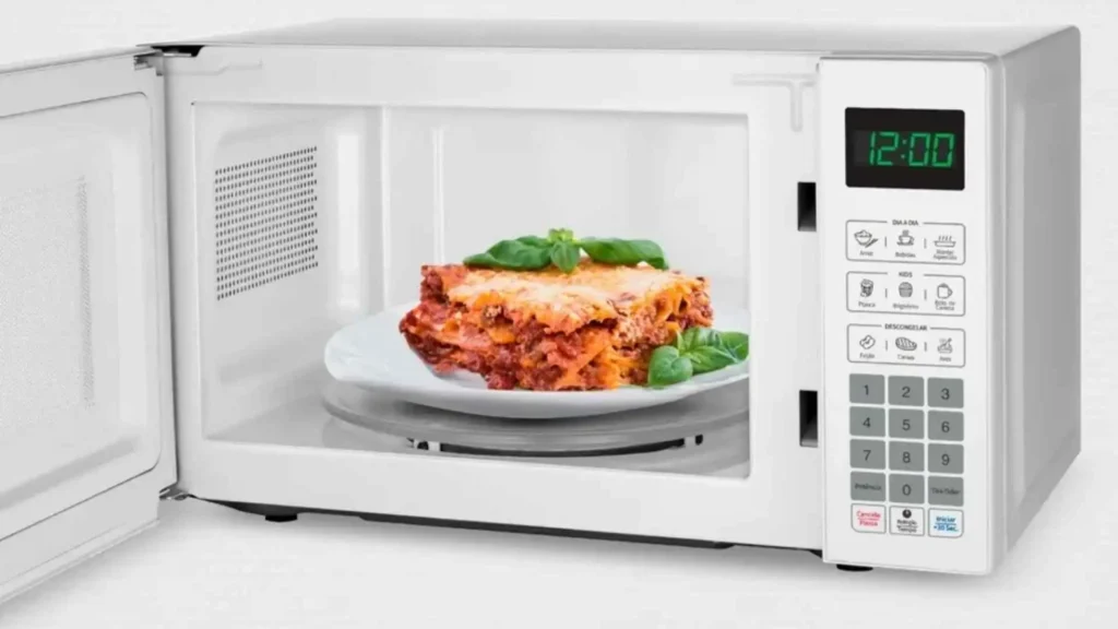 Interior do micro-ondas 21L Mondial MO-01-21-W com prato de vidro e alimento aquecendo