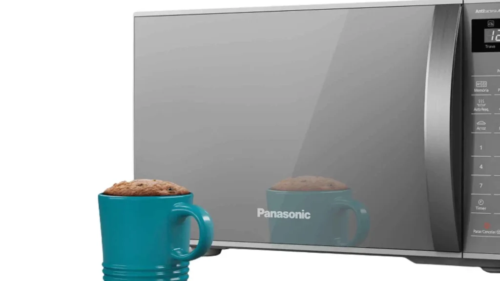 Detalhe da porta espelhada do micro-ondas Panasonic 21L NN-ST27L ao lado de uma xícara