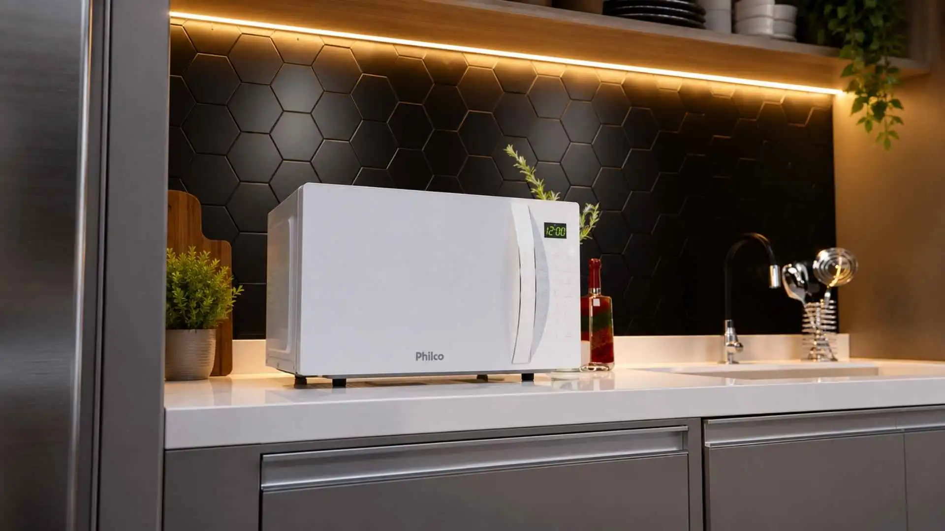 Micro-ondas Philco 28L PMO30B branco instalado sobre a bancada de uma cozinha planejada