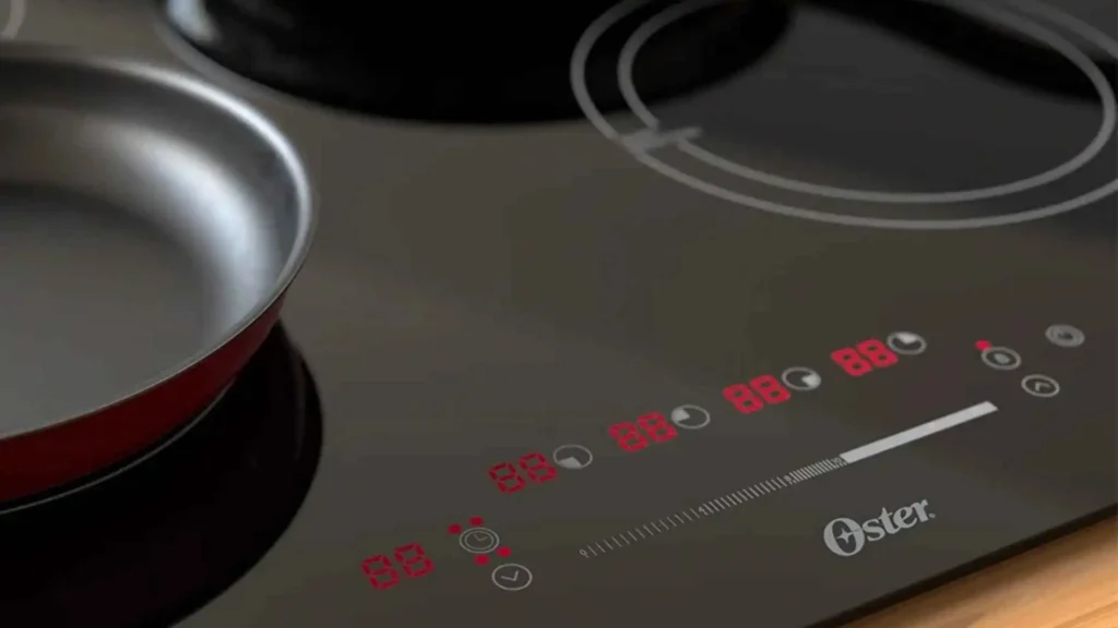 Detalhe aproximado do painel digital com controle Slide Touch iluminado do cooktop de indução 4 bocas Oster