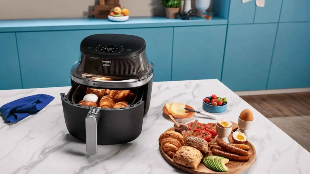 Visão frontal da Airfryer Philips Walita Série 3000 XL com a gaveta aberta mostrando o visor transparente e alimentos sendo preparados no cesto