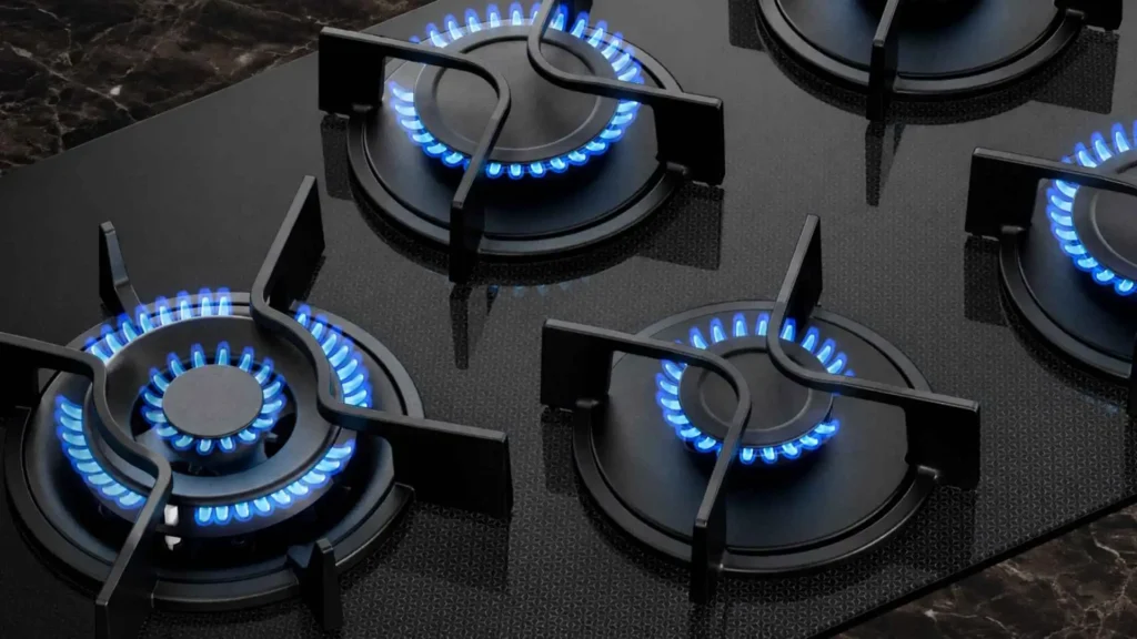 Detalhe aproximado dos queimadores acesos e das trempes individuais de ferro fundido do Cooktop 5 Bocas Electrolux Pro Series KE5PS