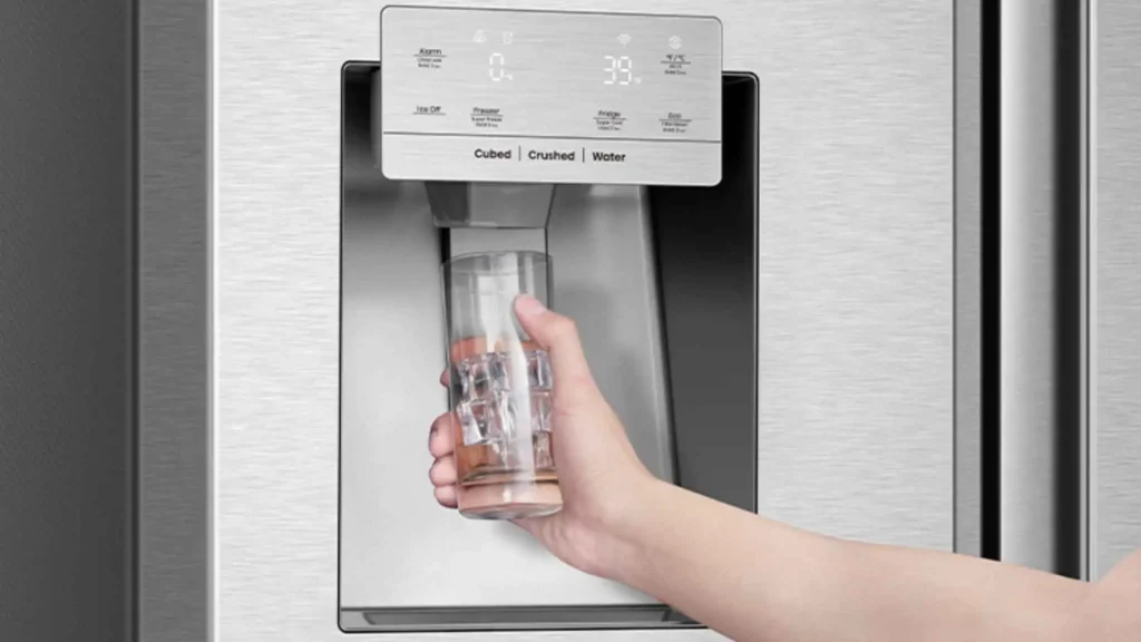 Pessoa utilizando o dispensador de água e gelo na porta do refrigerador Hisense 536 litros inox